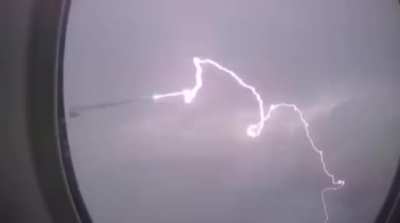 Lightning strikes the wing of a plane over Paris, France.