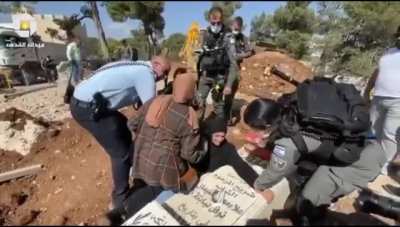 Israeli police separating a Palestinian mother from her child grave in a 16th century Palestinian graveyard to build a 