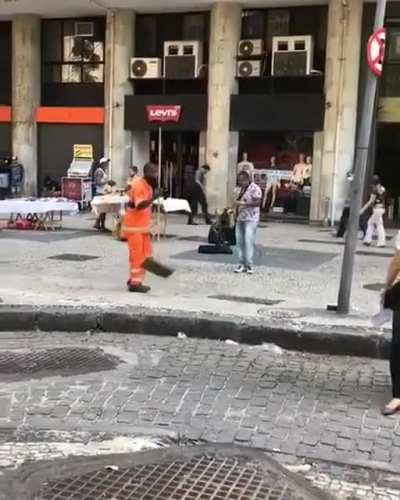 Street sweeper dancing while he clears the streets of Rio de Janeiro