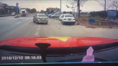 Watch the mother holding her baby near the white car