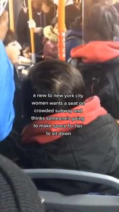 Women expects seat to be given up to her on a crowded subway