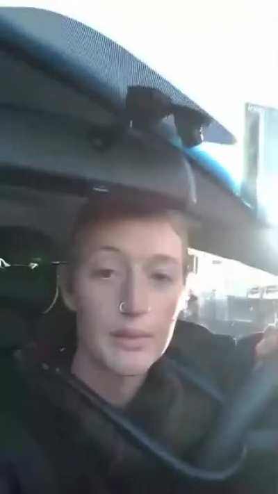 Climate activist gets confronted by an angry man after blocking off a busy road during peak hour.