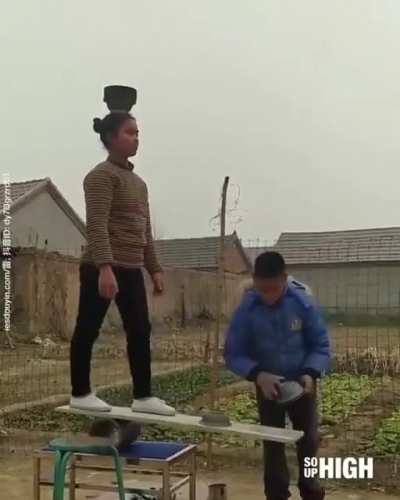Girl is balancing containers on her head.