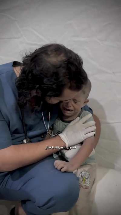 A doctor is trying to calm down a terrified and trembling child.