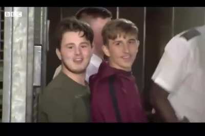 Two boys laughing on their way to court for killing a police officer, later on they were convicted of manslaughter.