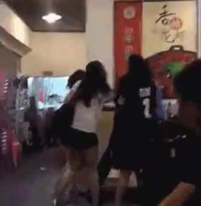 A pack of girls bullying somebody on the ground