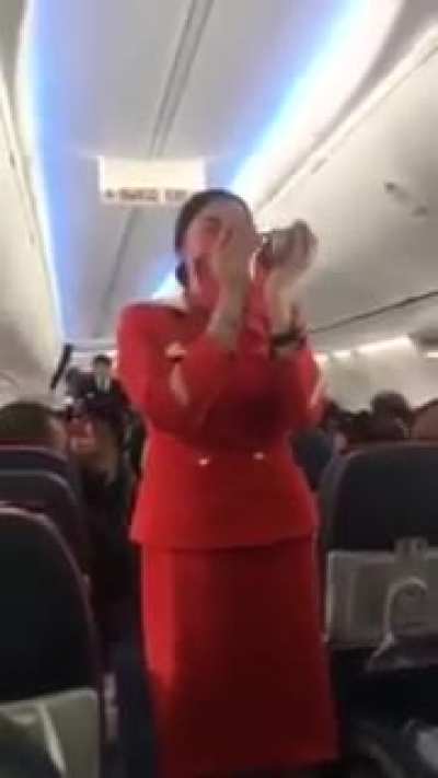 Football fans on flight distracting the air hostess doing the safety announcement