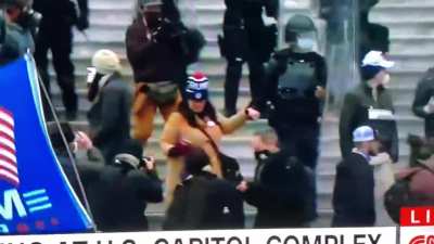 Riot police officer holds domestic terrorists hand to gently walk her down the stairs after she takes part in an assault on a federal building while the VP and VP elect were inside. Imagine if she was Muslim or black.