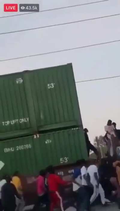 Looters robbing a slowly moving train