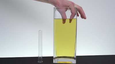The borosilicate glass and the oil have roughly the same index of refraction, so this clear beaker has no markings and bends light to the same degree as cooking oil.