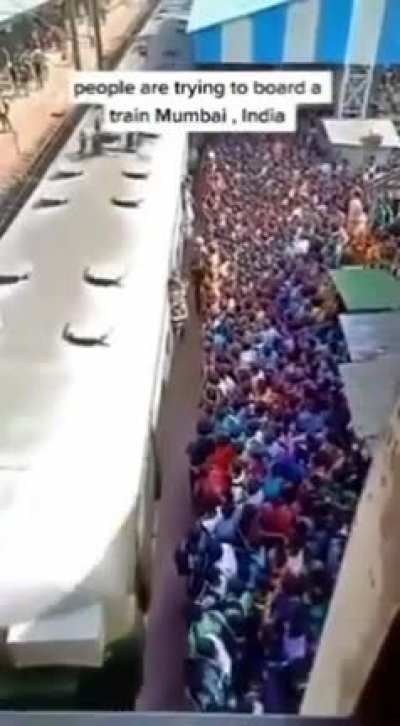 People in Mumbai trying to board a train.