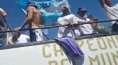 People jump onto the bus during Argentina national team's victory parade