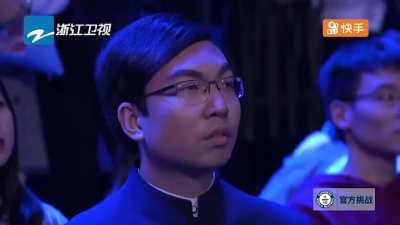 An entire audience seeing this kid solve Rubik's cubes while juggling