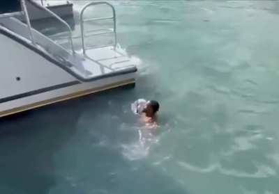 Man attempts to board moving boat from water.(NSFW-Injured by Propeller)
