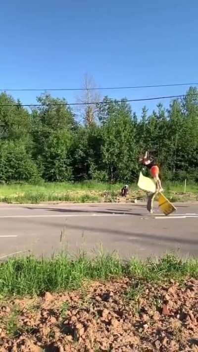 A guy backflips over running cars