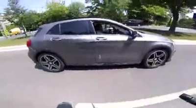 Motorcyclist gets hits by a car, follows her to make her pull over and gets stopped by other people who try to protect her.