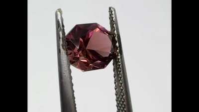 Tourmaline - 1.41ct 7.41x6.13mm. This is Congo Tourmaline, cut in Tom's Baroness design. It's bronze with distinct pink flashes. I love this colour (although it doesn't much love me. The tweezer photo is closer to what I see than the colour on my hand.) R