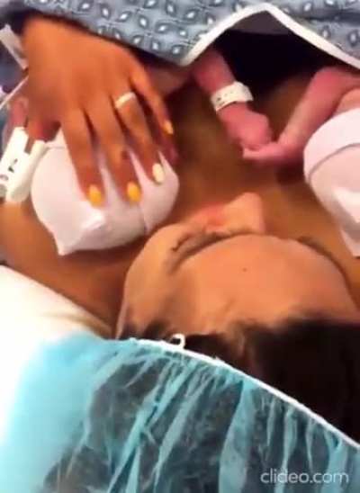 Newborn twins holding each other's hands