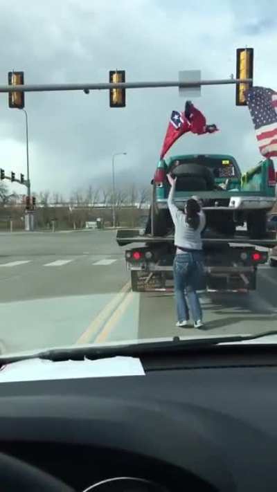 Woman rips hate symbol off of truck in the middle of a busy road.