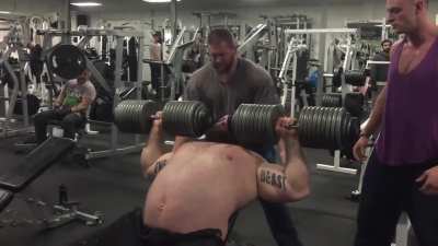 Strongman Eddie Hall looking like a Kodiak Bear lifting 220lbs dumbbells on each hand during training session