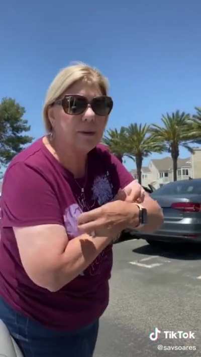 Karen sits on a woman’s car to prevent her from taking a parking spot