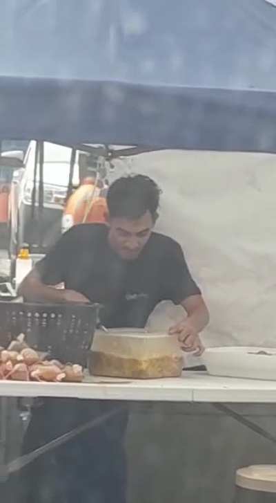 Food handler is spitting in the food he prepared. Is it normal? 