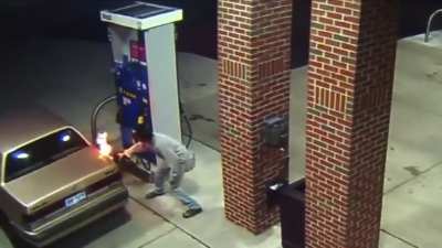 Guy tries to burn a spider while pumping gas