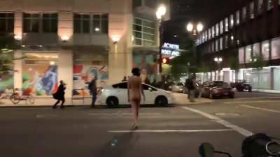 Nude woman standing before riot police in Portland. She's been nicknamed 