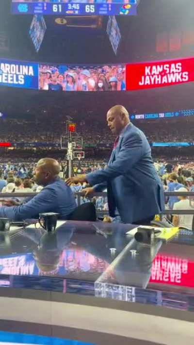 Basketball analyst and HOF Charles Barkley (standing) picked Kansas Jayhawks to win vs. North Carolina Tar Heels. Kenny Smith (sitting) also basketball analyst and former NBA player, who went to school in NC, picked the NC. Jayhawks won the game and whole