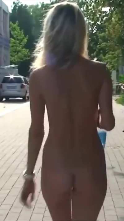 A naked blonde strolls along the embankment