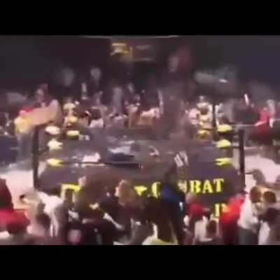 Dozens of chairs from the crowd rain down on the wrestlers