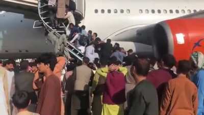Afghans trying to get on one of the last planes out of Kabul after the Taliban took over