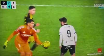 GK shoots ball in striker's arse