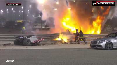 View from across the track of the flames and Grosjean being helped out