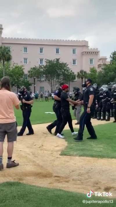 Police arresting a peaceful protestor for simply speaking to them.