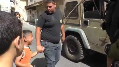 Heavily armed Israeli soldiers arrest a Palestinian child