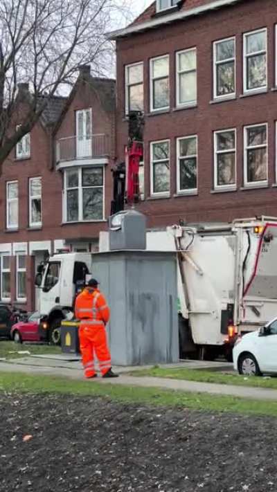 This is how the Dutch garbage bins work. They have a large underground storage that are lifted out for waste disposal. What you have is a standard smaller receptacle on the ground. These are also segregated by waste type in most areas.