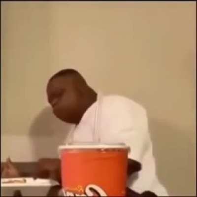 Black man falls off chair