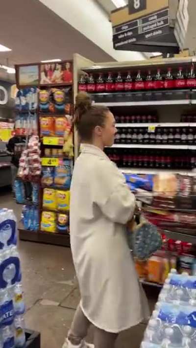 Woman spitting in and resealing chips at supermarket