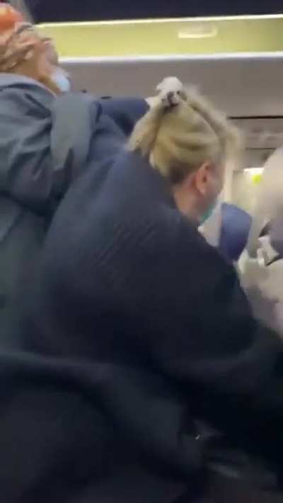 Woman on airplane blocks the way for people and pretends she’s getting attacked