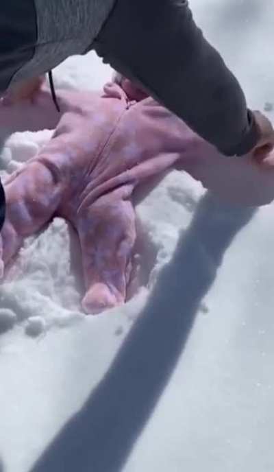 Baby's reaction after her first snow angel with some help from her dad