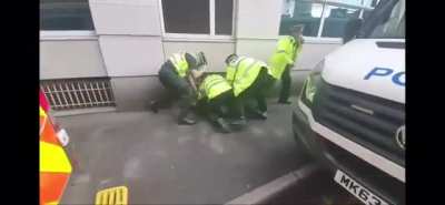 A police officer punches a Manchester United fan at the protest against Glazer ownership, outside Old Trafford