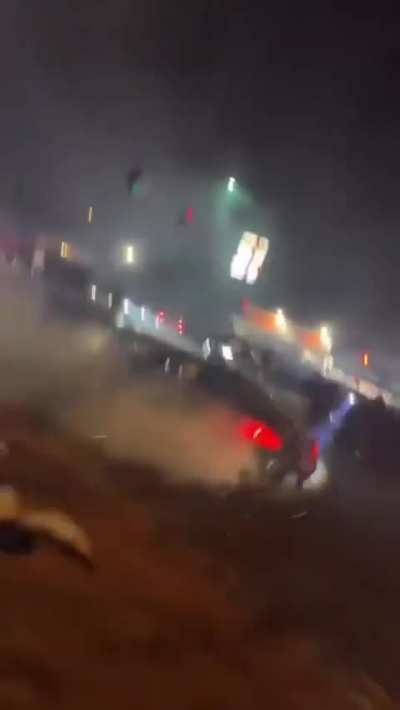 idiot runs towards car doing donuts and gets striked