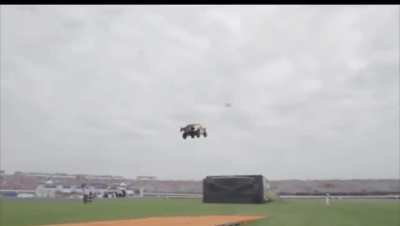 Driver Tanner Foust drops 90 feet down of orange track & soars 332 feet through the air .