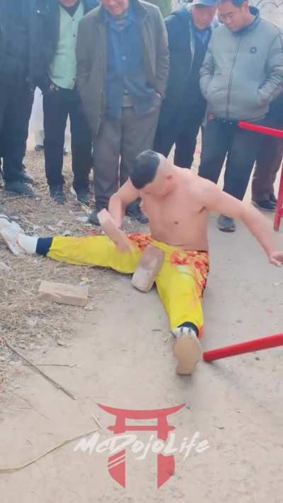 Kung-Fu performer breaks a brick placed directly on his ballsack.