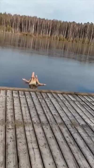 Woman tries to take a jump and break some ice on a frozen lake..