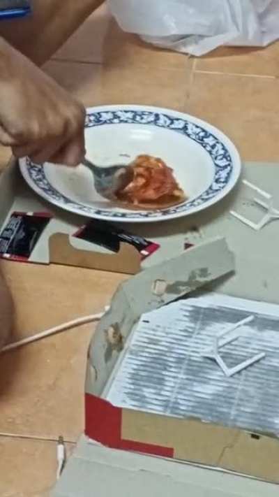 My friend eating Pizza with a spoon.