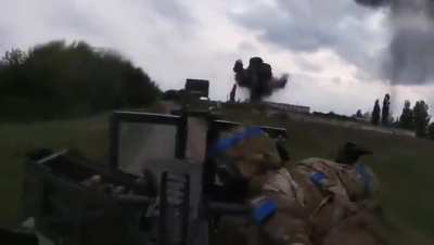 Ukrainian troops in a Mk 19 Humvee approaching a village outskirts while it's being hit by artillery