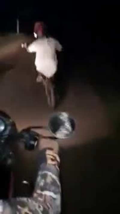 Adults bullying a kid on a bicycle on a dark road