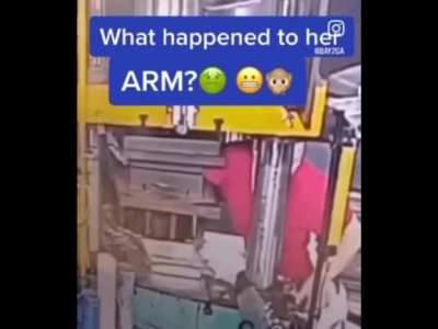 Woman puts her arm into stamping machine